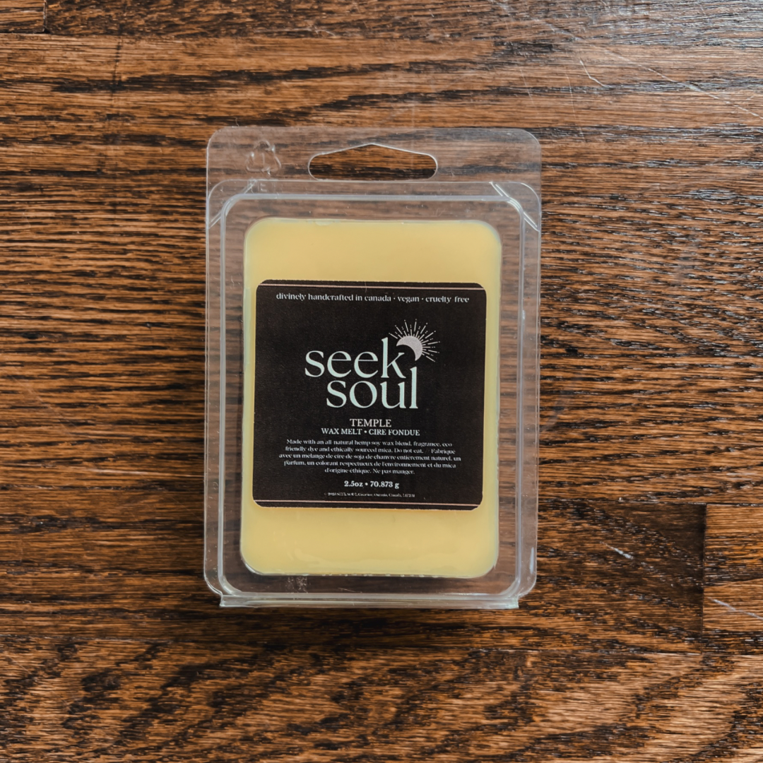Photo of our Temple Wax Melts. Melts are golden in colour and there are 6 large cubes. Packaging is clear, recyclable and approximately 4” long. Box has a black label on the front with the SEEK SOUL logo on it.