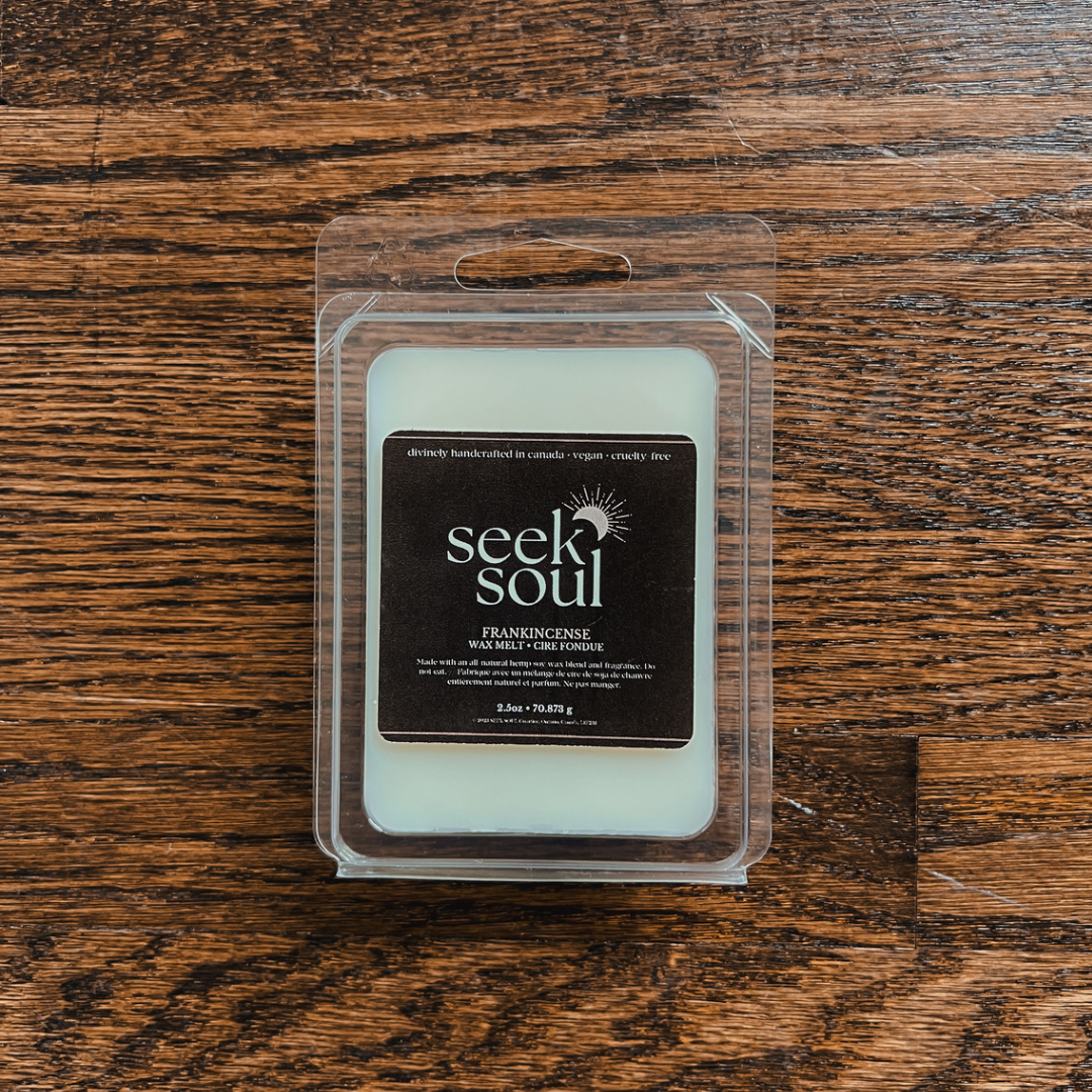 Photo of our Frankincense Wax Melts. Melts are off-white in colour and there are 6 large cubes. Packaging is clear, recyclable and approximately 4” long. Box has a black label on the front with the SEEK SOUL logo on it.
