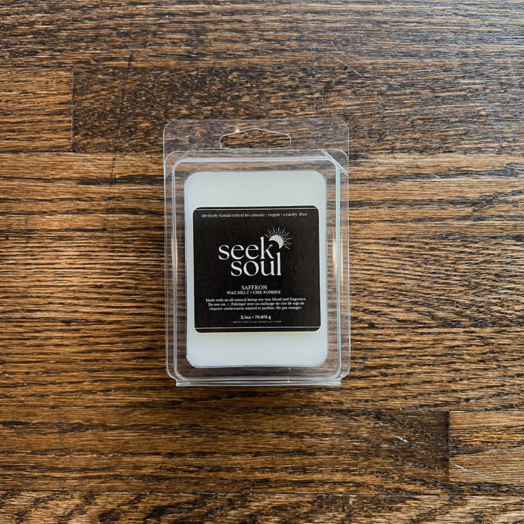 Photo of our Saffron Wax Melts. Melts are off-white in colour. There are 6 large cubes. Packaging is clear, recyclable and approximately 4” long. Box has a black label on the front with the SEEK SOUL logo on it.