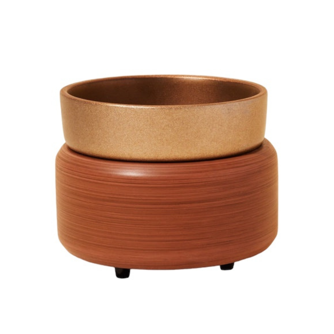 Photo of our Walnut Wax Warmer. It is circular in shape with a removable round dish sitting on top. It has tiny black feet on the bottom and is brown in colour with a golden dish.